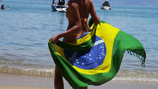一个巴西女孩穿着巴西国旗的沙滩布裙跳舞视频素材