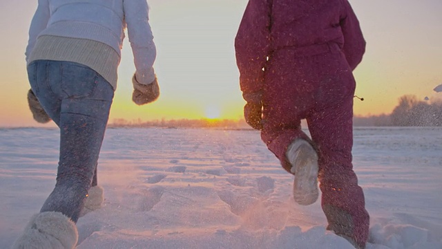 母亲和女儿在雪地里跋涉视频素材