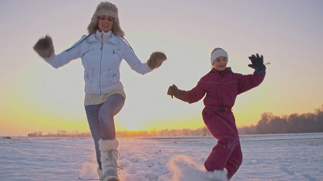 妈妈和女儿在雪中奔跑视频素材