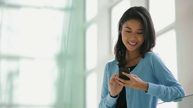 MS年轻女子发短信在她的智能手机靠近窗口。视频素材