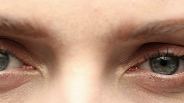 一位年轻女子眨着绿色的眼睛。视频素材