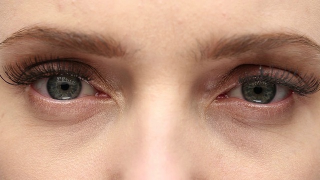 一位年轻女子揉着她的一双绿眼睛。视频素材