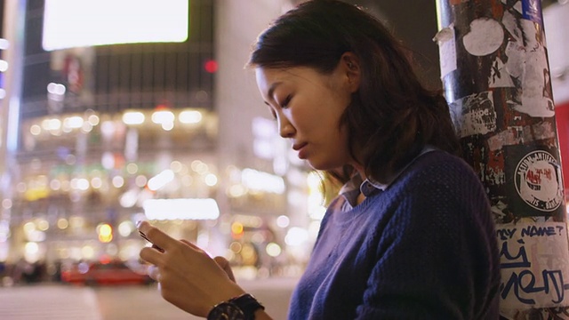 日本东京，一名年轻的日本女子用她的手机拍摄涉谷十字路口视频素材