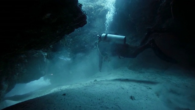 潜水者在珊瑚礁的洞穴中游泳视频素材
