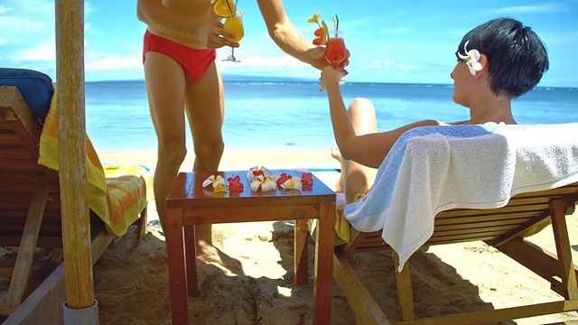 一对夫妇在海滩上喝鸡尾酒视频素材
