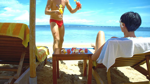 WS夫妇在海滩上喝鸡尾酒视频素材