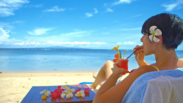 在海滩上喝鸡尾酒的女人视频素材