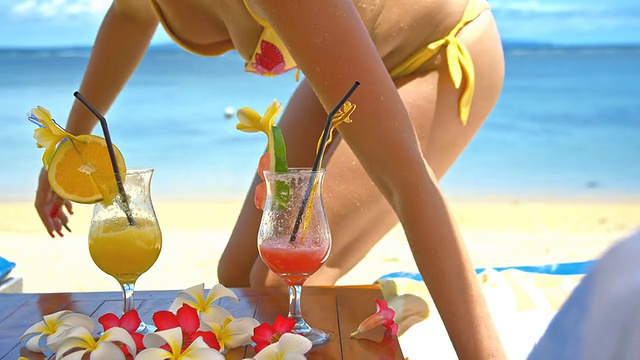 在巴厘岛海滩上喝鸡尾酒的女士视频素材