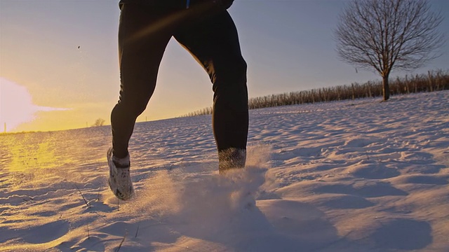 SLO MO慢跑者在雪地里跋涉视频素材