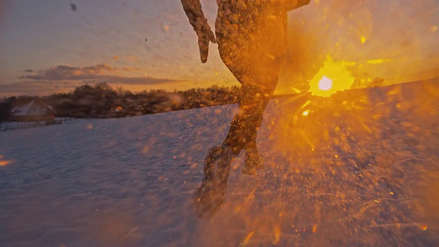 慢动作在夕阳下的雪中慢跑视频素材