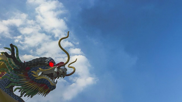 时间流逝:中国龙雕塑与移动的云背景视频下载