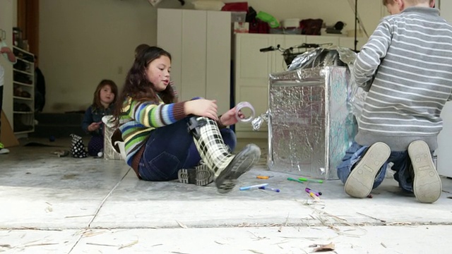 一群年轻的孩子用回收材料建造一个机器人。视频素材