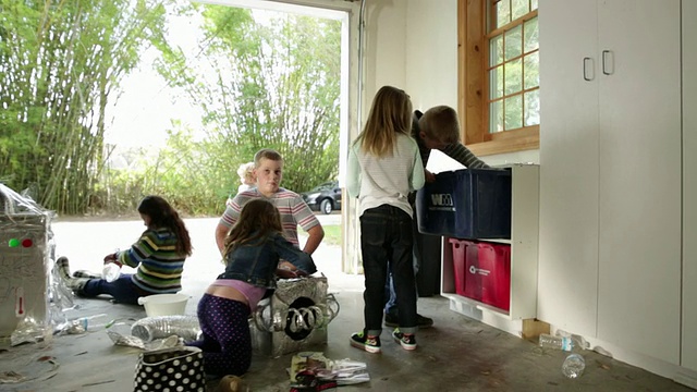 一群孩子用回收材料制作机器人。视频素材