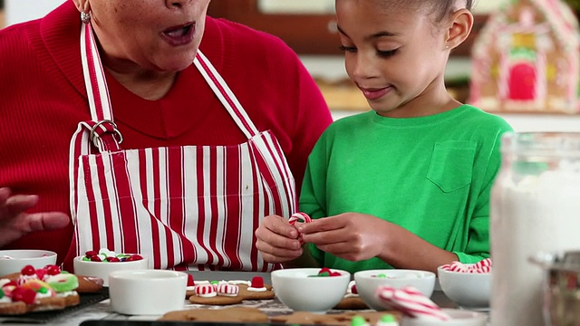 美国弗吉尼亚州里士满厨房的祖母和孙女装饰姜饼人饼干视频素材