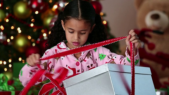 屠女士兴奋的小女孩打开圣诞礼物/里士满，弗吉尼亚州，美国视频下载