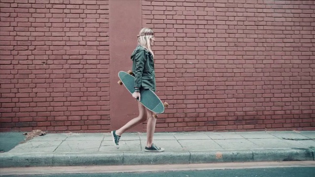 带着滑板走在街上的女人视频素材