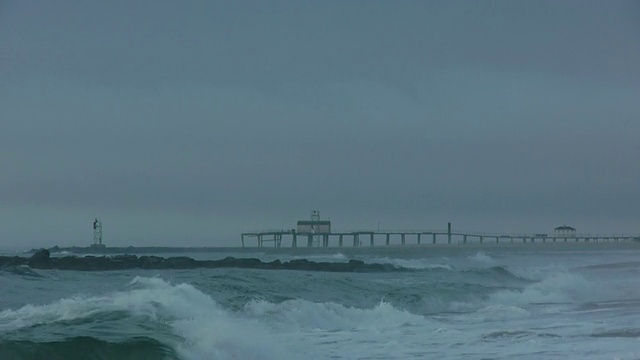 WS风驱动的波浪撞击防波堤和海滩，钓鱼码头的背景，阴沉的天空，埃文海边，新泽西州，大西洋视频下载
