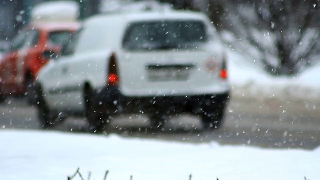 暴风雪。冬季交通。汽车在滑溜溜的路上行驶。下雪,雪花。视频素材