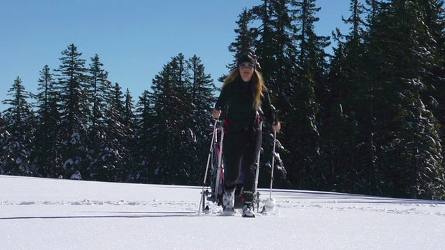高清拍摄的年轻女性拉滑雪拖车在雪景视频素材