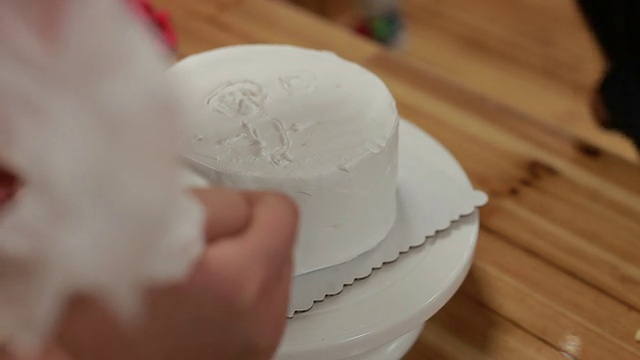 厨师在生日蛋糕上涂奶油，做成漩涡装饰视频素材