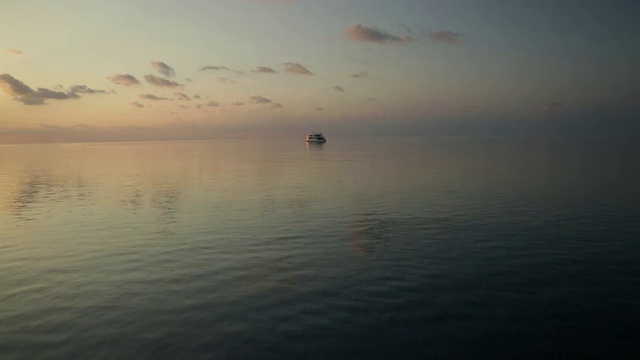游艇在平静的海面上日落，高架的视野视频素材