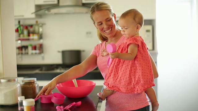 母亲和女儿一起在厨房烘焙。视频下载