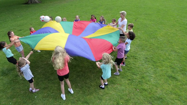 孩子们用降落伞玩球类游戏视频下载