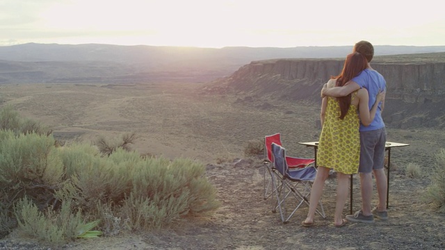 拥抱夫妇野餐俯瞰沙漠峡谷日落视频素材