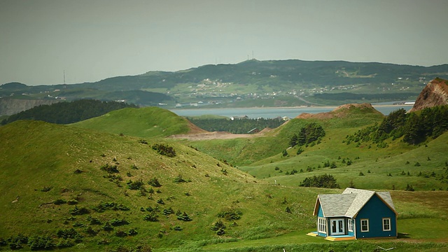 蓝色的小房子，周围是小山和田野视频素材