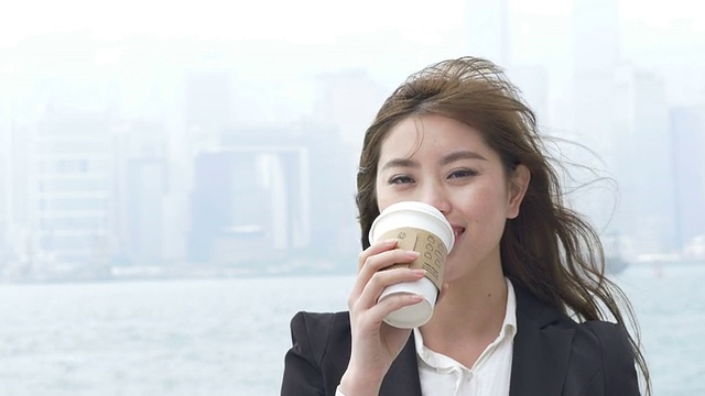 亚洲女商人喜欢在香港户外喝咖啡。视频素材