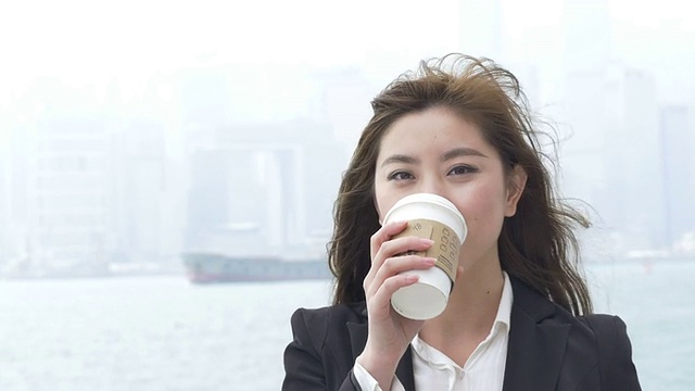 亚洲女商人喜欢在香港户外喝咖啡。视频素材