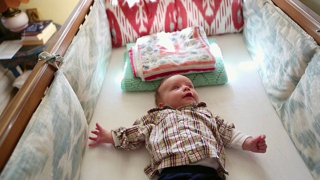 美国新墨西哥州拉米，婴儿在他的婴儿床上看着他的手机视频下载