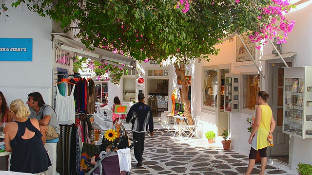 这是希腊米科诺斯岛的照片，有商店和购物者在城市中穿行，还有市中心的白色建筑视频素材