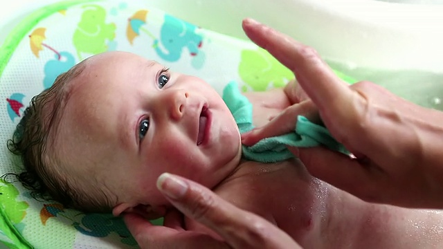 CU母亲给婴儿洗澡的照片/拉米，新墨西哥，美国视频素材