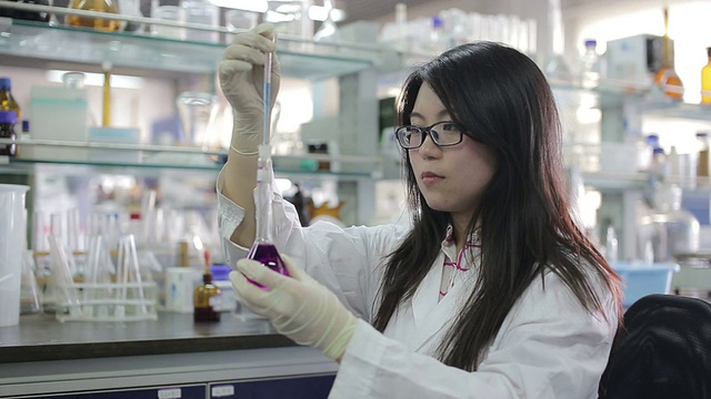 亚洲女科学家看着烧杯液体视频素材