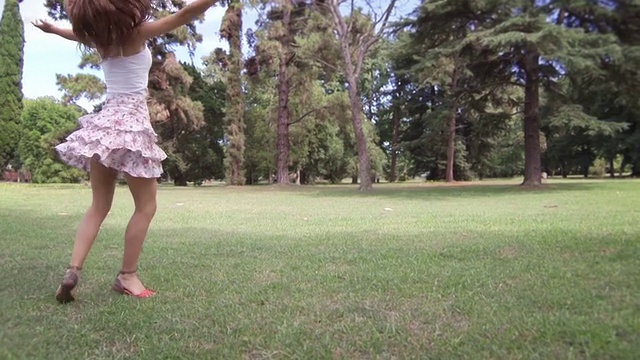 年轻女子在公园里纺纱跳舞。缓慢的运动。视频下载
