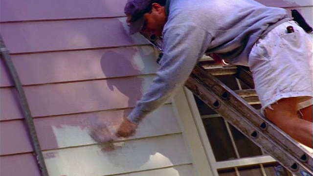 后视图倾斜下来的人在梯子上油漆房子外部薰衣草视频下载