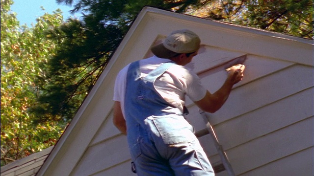 后视镜拍摄的人在梯子上油漆房子外部薰衣草视频下载