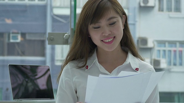 亚洲商业女性持有文件，并表达积极。视频素材