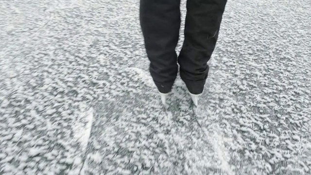 在蒙大拿冰川公园，溜冰的人在一个冰冻的山湖上滑冰视频素材