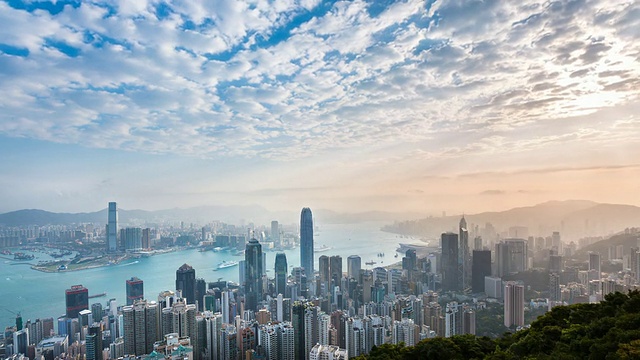 时间流逝，香港天际线和维多利亚港沐浴在清晨的阳光视频下载