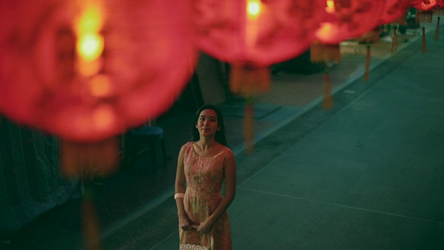 一个女人站在大街上，灯笼下。视频素材