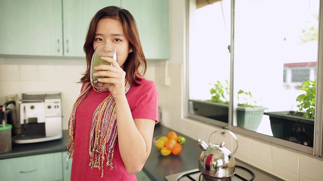 厨房里拿着果汁的中国女人视频素材