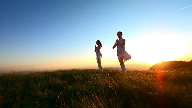 一对在日落时练习瑜伽的夫妇视频下载