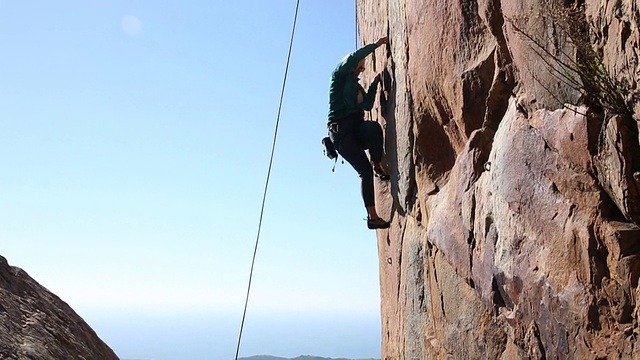 攀登者在海面上陡峭的悬崖上保护队友视频素材