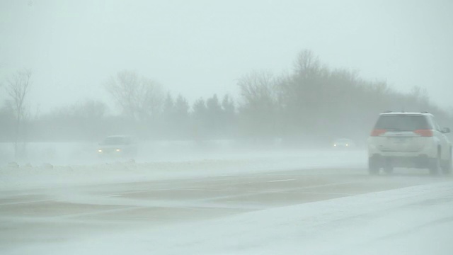 冬季暴风雪与吹雪横跨高速公路和车辆视频素材