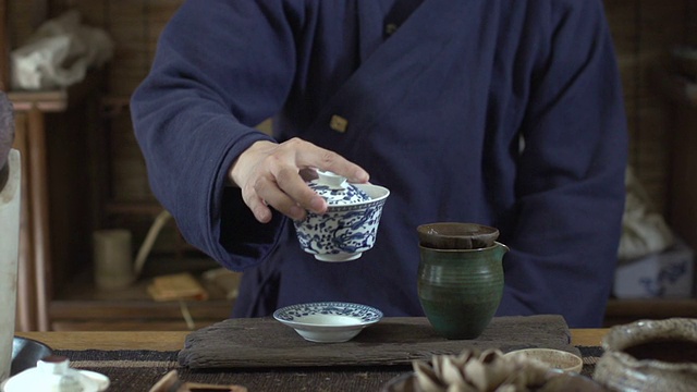 男人往杯子里倒茶，慢镜头视频素材