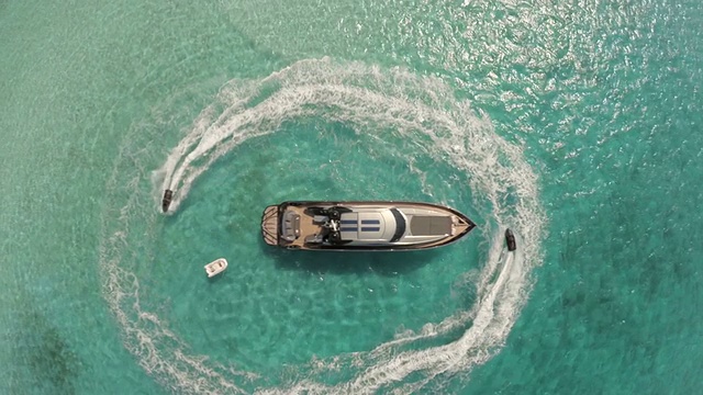 无人机鸟瞰环绕豪华游艇的水上摩托视频下载