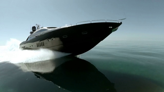 无人机追踪到豪华游艇在巴哈马群岛静止的水面上高速行驶。视频下载