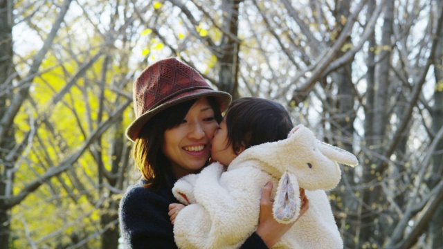 年轻的日本母亲与她1岁半的女儿在公园里玩得很开心视频素材